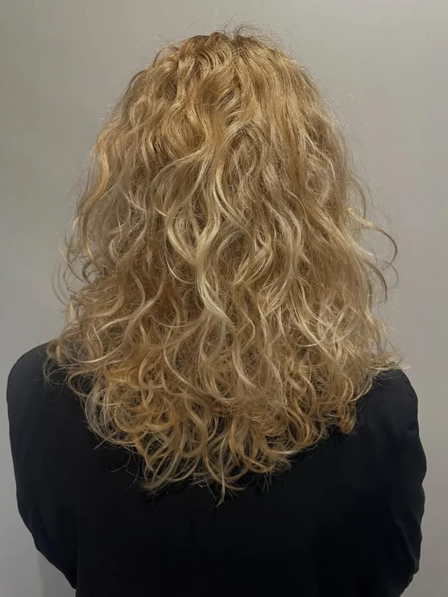 Coloration blond lumineux sur cheveux bouclés au Comptoir des Couleurs à Dunkerque